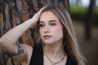 Genç, güzel bir kadının portresi, sarışın, yeşil gözlü, siyah bluzlu, bir ağacın gövdesine nazikçe ve tatlılıkla yaslanan sonsuzluğa bakan. Şefkat kavramı, masumiyet.