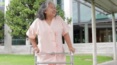 Asyalı yaşlı kadın hasta hastaneye kaldırıldı. Vücudu eski haline getirmek için dört ayak üzerinde yürümek için baston tutun. yaşlı sağlık hizmetleri kavramı