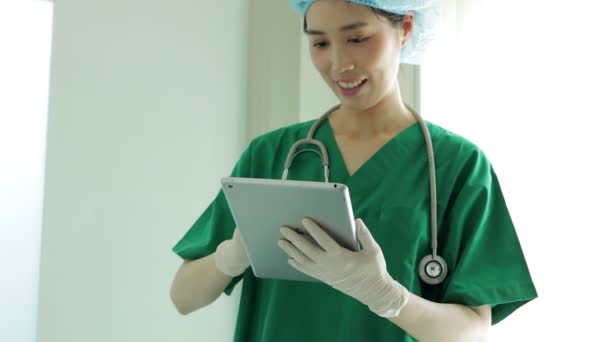 Asian Female Doctor Wearing Surgical Gown Holding Tablet Review Patient — Stock Video