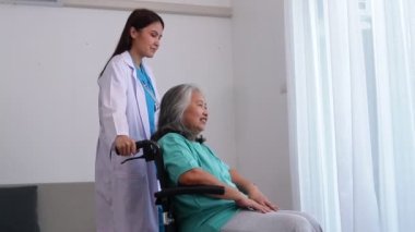 Asyalı kadın doktor depresyon geçiren yaşlı hastaları tedavi ediyor. Tekerlekli sandalyede oturuyordu. Kıdemli hastalar kavramı. Yaşlılar Sağlık Merkezi