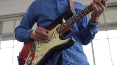 Müzik çalışma odasında elektro gitar çalan Asyalı profesyonel müzisyen. Canlı müzik ve bando çalma kavramı. Müzik bir kayıt stüdyosunda çalınır..