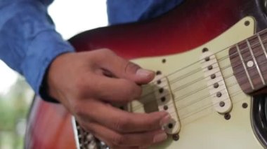 Müzik çalışma odasında elektro gitar çalan Asyalı profesyonel müzisyen. Canlı müzik ve bando çalma kavramı. Müzik bir kayıt stüdyosunda çalınır..