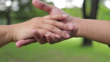 Bakıcı, yaşlıların elini tutmaktadır. Yaşlılar için sağlık hizmeti kavramı. Ailede sevgi göstermek, birbirimize sahip çıkmak..