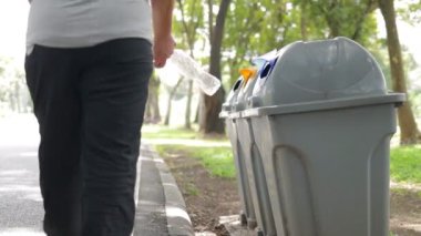 Asyalı yaşlı kadın plastik şişeleri al ve çöpe at. Küresel ısınmayı azaltmak için plastik atıkları temiz tutma kavramı. Geri Dönüşüm Arti