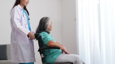 Asyalı kadın doktor depresyon geçiren yaşlı hastaları tedavi ediyor. Tekerlekli sandalyede oturuyordu. Kıdemli hastalar kavramı. Yaşlılar Sağlık Merkezi