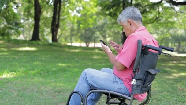Azjatycki Starzec Wózku Inwalidzkim Ogrodzie Grać Mobilne Media Społecznościowe Online — Wideo stockowe