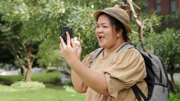 Gruba Kobieta Hamburgera Trzyma Smartfona Rozmawiającego Przyjaciółmi Gruba Azjatka Podróżująca — Wideo stockowe