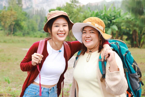 Portrait Two Asian Female Travelers Carrying Backpacks Hugging Necks Smiling — Stock Photo, Image