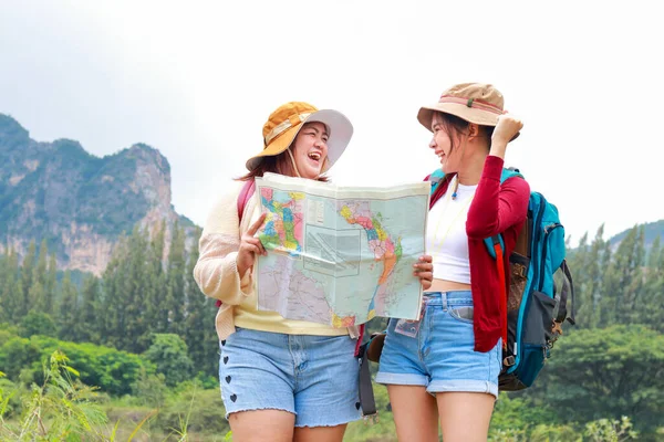两个背着背包的亚洲女性旅行者站在那里看地图去旅行的肖像 笑得开心 旅行概念 徒步旅行 — 图库照片
