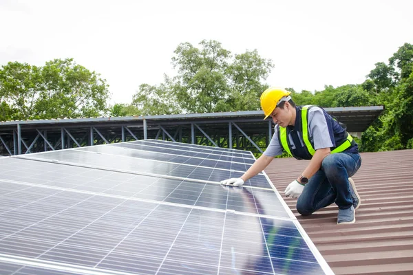 Asian technicians install panels Solar cells to produce and distribute electricity. Energy technology concept. copy space