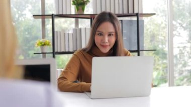 Ofisteki güzel Asyalı kadın konferans odasında dizüstü bilgisayar kullanarak oturuyor. İş konsepti. Ofiste çalışan şirket çalışanları.