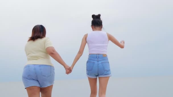 Dvě Tlusté Hubené Asijské Ženy Které Drží Ruce Utíkají Moři — Stock video