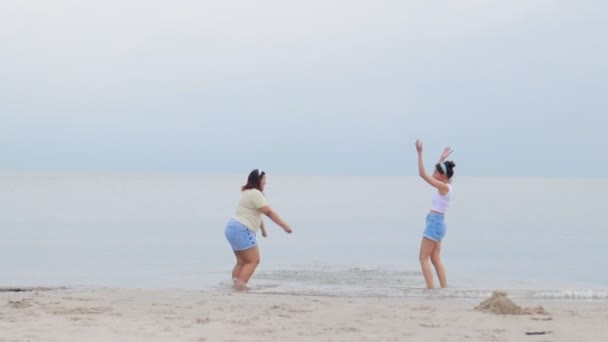 两个又胖又瘦的亚洲女人在海滩上很快乐 他们都在海里玩得很开心 自然旅游的概念在周末放松 — 图库视频影像