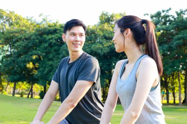 Sabahları parkta birlikte egzersiz yapan Asyalı çift güçlü ve sağlıklılar. Açık hava egzersiz konsepti, sağlık hizmetleri
