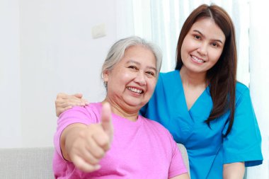 Fizyoterapist portresi ya da mutlu gülümseyen Asyalı yaşlıların bakıcısı. Tıbbi servis konsepti. yaşlı sağlık hizmetleri