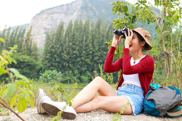 Doğa turizminin tadını çıkaran Asyalı kadın turist kuş gözlemi için dürbün kullanıyor. Macera hayat yolculuğu konsepti, gezgin, yürüyüş. Boşluğu kopyala