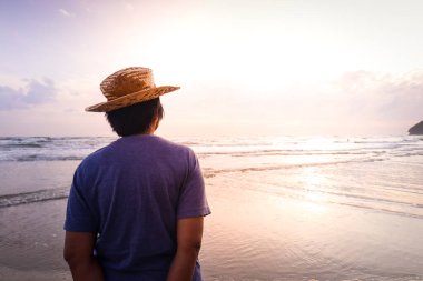 Akşamları sahilde tek başına duran Asyalı yaşlı kadın. Yaşlı turistler. Emeklilik hayatı. Boşluğu kopyala