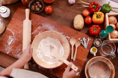 Üst Manzara. Şef pizza yapmak için fırın hamurunu karıştırıyor. İtalyan yemeği konsepti, fast food.