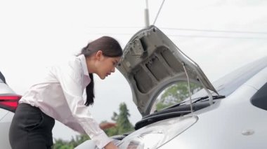 Yolda araba kazası geçiren Asyalı bir kadın motoru tek başına kontrol ediyor ve sigorta şirketinden yardım bekliyor. Taşıma konsepti, araba kazası.