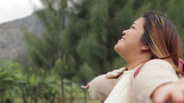 アジアの太った女性は 自然の中で幸せに笑顔を浮かべ 高い山の背景に立っています 旅行コンセプト アドベントロウス リビング クライマー 観光客 バードウォッチャー — ストック動画