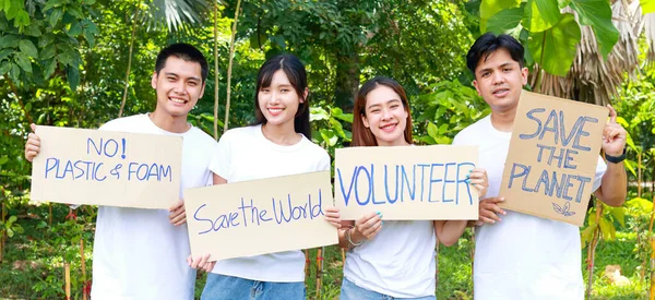 亚洲青年志愿者小组举着支持自然和环境的标志 社会志愿者概念 世界环境日 图库图片