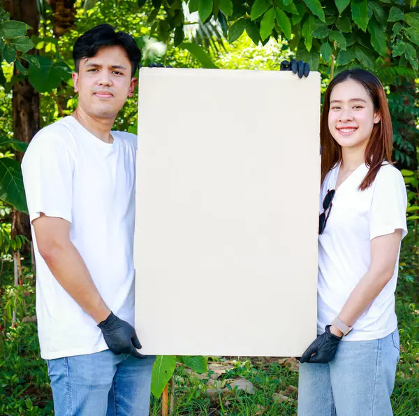 一群年轻的亚洲志愿者举着一张棕色的纸 空白处写着一条信息 支持大自然与环境 社会志愿者概念 世界环境日 图库图片