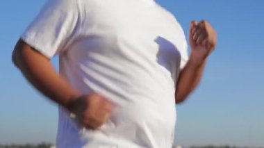Beyaz gömlekli şişman adam sabah dışarıda koşuyor. Spor konsepti. kilo vermek için egzersiz