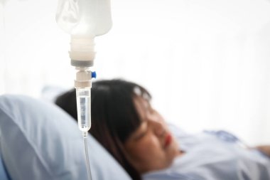 Obez kadın hastane yatağında yatıyor, doktor tuz çözeltisi veriyor. Obezite, diyabet, yüksek tansiyon, sağlık sorunları. Sağlık sigortası yaptırıyorum