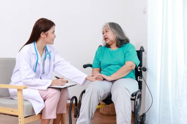 Kadın bir doktor, tekerlekli sandalyede oturan yaşlı bir kadın hastayı tedavi ediyor. Kıdemli sağlık hizmetleri. Hastanelerde tıbbi hizmetler
