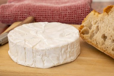 Ahşap bir tahtanın üzerinde camembert peyniri.
