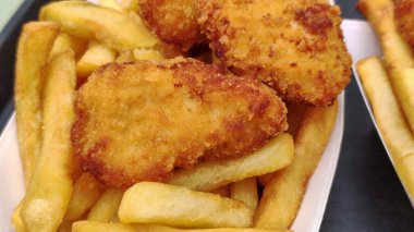 Tavuk nugget ve patates kızartmasını tepside yakın.