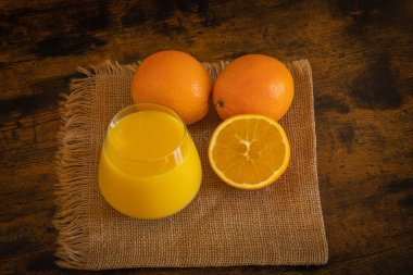 bir bardak portakal suyu ve portakallar bir masaya yakın çekim