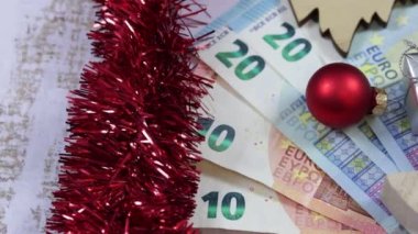 Arkaplanda banknotlar ve Noel süslemeleri var