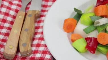 Bir tabak çiğ sebze yakın.