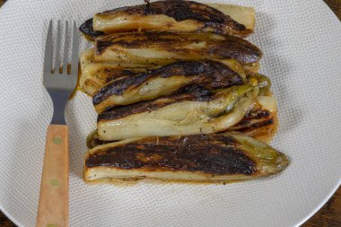 Bir tabak haşlanmış hindiba. Bir masaya yakın plan.