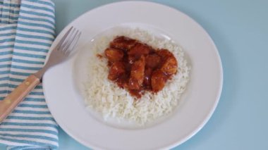 Bir tabak beyaz pirinç ve domatesli domuz eti.