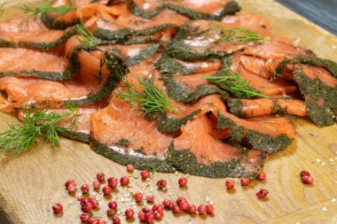 Kesme tahtasının üzerinde dereotlu, yakın plan füme somon dilimleri.