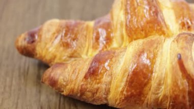 Tahta bir arka planda kruvasan yakın plan.