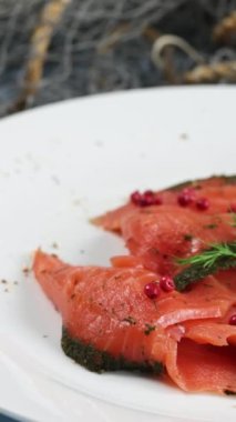 Dilimler halinde tütsülenmiş somon, dereotlu, yakın plan, tabakta.