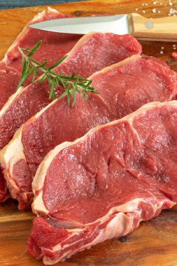 close up raw beef rib eye on cutting board