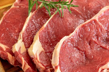close up raw beef rib eye on cutting board