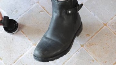 person polishing a pair of shoes close-up