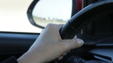 close up of a person's hands driving a car