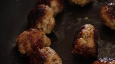 Tavada pişen domuz köftesi.