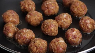 Tavada pişen domuz köftesi.