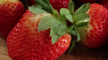 Yakın plan birkaç çilek, ahşap bir arka planda izole edilmiş.