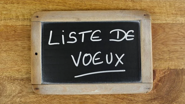 フランス語で 願い事リスト という単語が孤立したスレートで書かれています — ストック写真