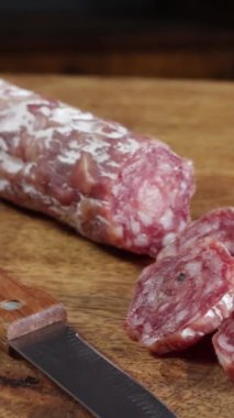 sliced dry sausage close-up on a wooden table