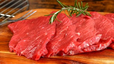 Birkaç çiğ biftek, yakın plan, kesim tahtasının üzerinde.