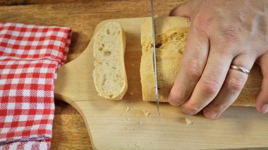 Ciabatta ekmeğini dilimlere ayıran kişi